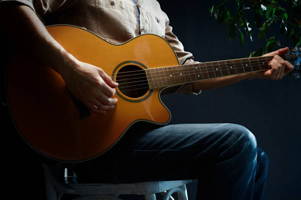 praticare la chitarra acustica. uomo che suona la chitarra. chitarrista sul palco - guitarist foto e immagini stock