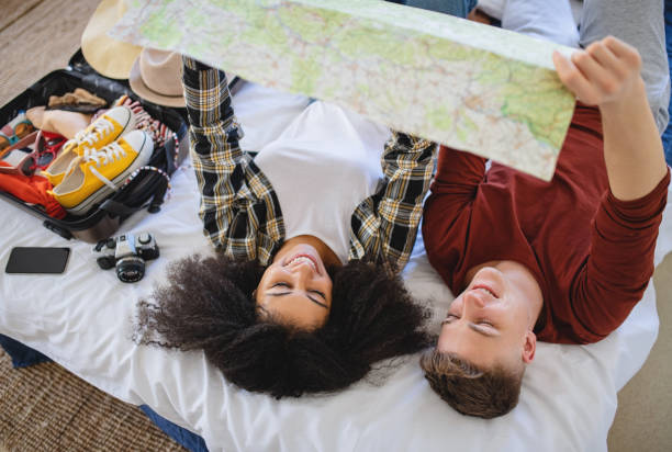 istock Young couple with map packing for holiday at home. 1316426572