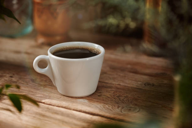 Cup of coffee on outdoors table with soft creamy bokeh in a sunny day Cup of coffee on outdoors table with soft creamy bokeh in a sunny day BLACK COFFEE stock pictures, royalty-free photos & images