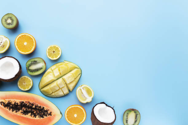 istock Different fresh tropical cut fruits on a blue background 1316428090