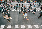 People wearing masks walking on zebra crossing