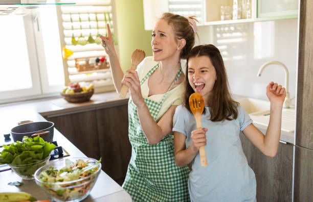 istock Young mother and daughter having fun singing in the kitchen 1316434086