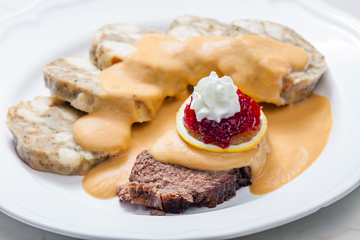 sirloin sauce with dumplings and cranberries on lemon with whipped cream
