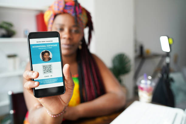 An African woman shows a digital vaccination passport on a phone display stock photo