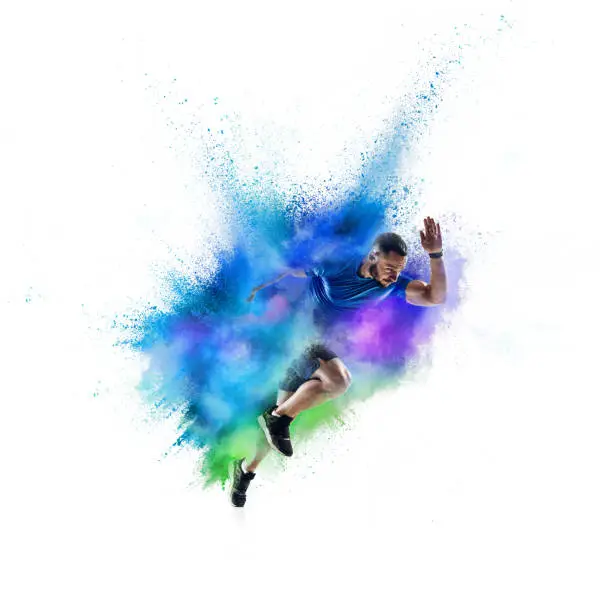 Photo of One Caucasian sportsman in explosion of colored neon powder isolated on white background