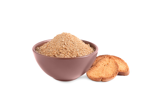 Fresh bread crumbs in bowl and toasts on white background