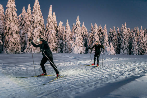 istock Two skiers skiing on snow at night 1316441543