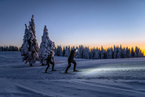 Men skiing on ski slope at night