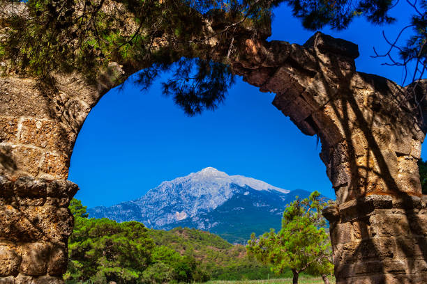 Landscape with Mount Tahtali Dagi and ancient aqueduct in Turkey on a sunny summer day stock photo