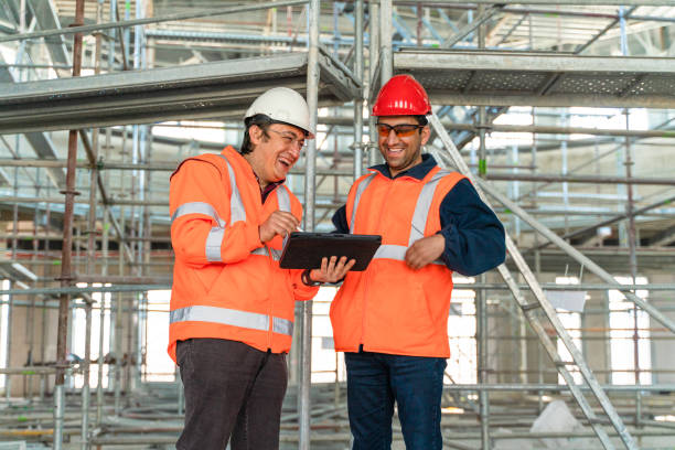 istock Two male engineers working on the steel construction site using digital tablets, smiling happily 1316443124