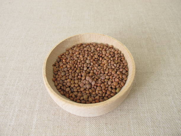 istock Brown mountain lentils in a wooden bowl 1316443334