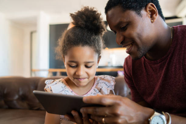 istock Father and daughter using digital tablet at home. 1316445596