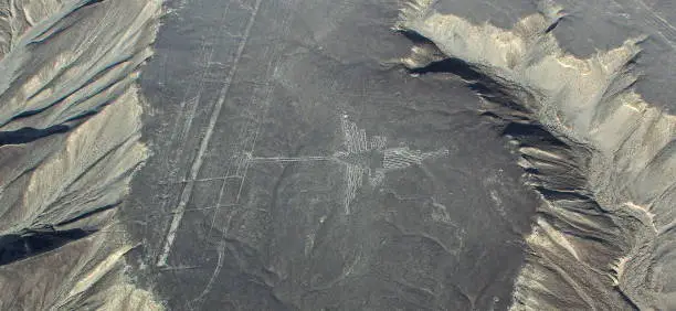Photo of Nazca aerial view, with interesting sandy hill formations and Colibri geoglyphic in the center, Peru