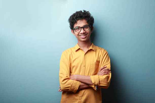 lächelnder junge indischer herkunft - männlicher teenager stock-fotos und bilder