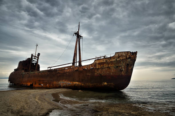 Dimitrios is an old ship wrecked on the Greek coast and abandoned on the beach Old ship wrecked on the Greek coast and abandoned on the beach, his name was Dimitrios. Photo representing the concept of abandoned and failure ship wreck shore storm stock pictures, royalty-free photos & images