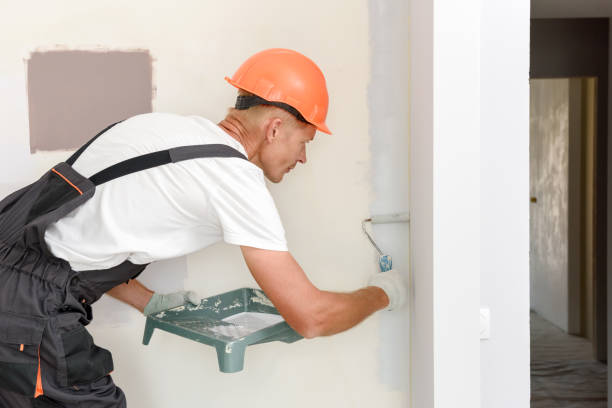istock The painter is painting a wall in a room with a roller. 1316453898
