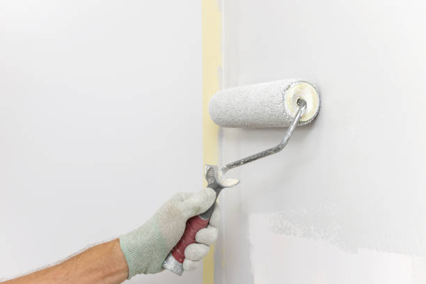 istock A painter is painting a wall in a room with a roller. 1316453901