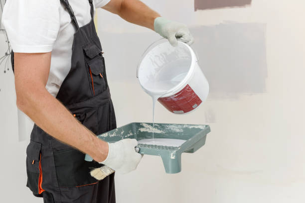 istock A painter is painting a wall in a room with a roller. 1316453924