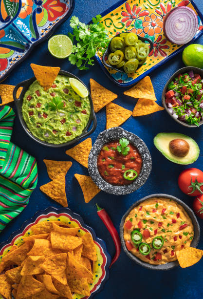mexikanische dip-saucen guacamole, cheedar dip, tomatensalsa und pico de gallo mit nacho-chips - traditional foods stock-fotos und bilder