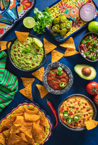 mexican dip sauces guacamole, cheedar dip, tomato salsa and pico de gallo with nacho chips - traditional foods imagens e fotografias de stock