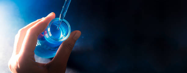 science blue glass tube experiment,flask in scientist hand with test tubes,laboratory glassware with a dropper dripping liquid into a test tube. scientific laboratory test tubes, laboratory equipment - laboratory glassware fotos imagens e fotografias de stock