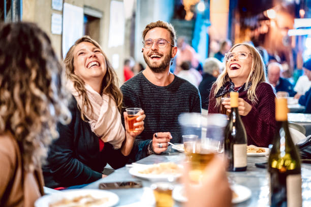 amici felici che si divertono a bere vino bianco al festival dello street food - giovani che mangiano piatto locale al ristorante riaprendo insieme - concetto di stile di vita di viaggio e pranzo sul filtro al neon azur light - dining table people foods and drinks restaurant foto e immagini stock