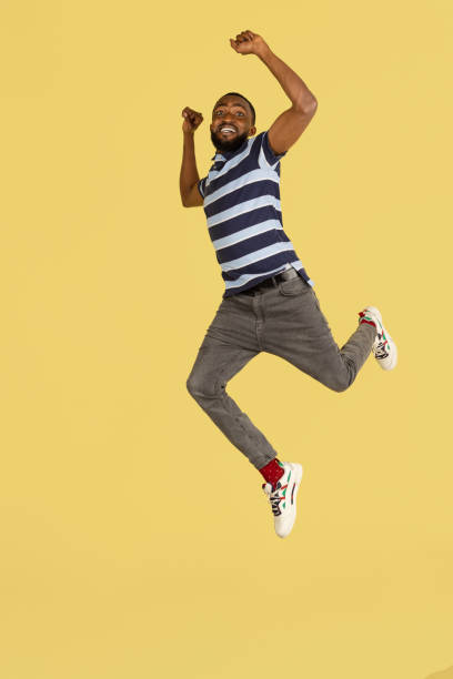 istock One African young man jumping isolated over yellow studio background with copyspace for ad 1316458438