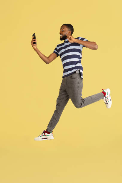 istock One African young man jumping isolated over yellow studio background with copyspace for ad 1316458467