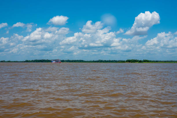 Meeting of the waters of Negro and Solimoes Rivers Typical passenger boat from the Amazon region sailing in Manaus, capital of the State of Amazonas The Amazon florest in the background rio negro brazil stock pictures, royalty-free photos & images