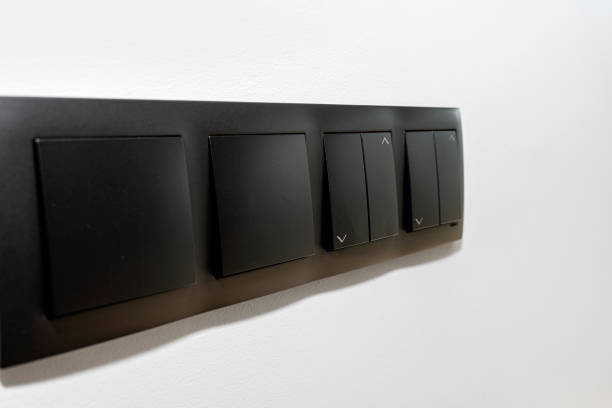 istock Black frame with a button to switch the lights and roller shutter up and down on the gray wall of the house. 1316461826