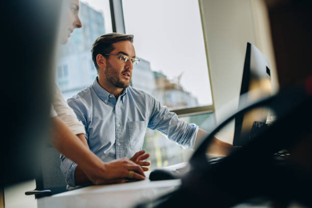 istock Manger helping coworker in new project 1316462424