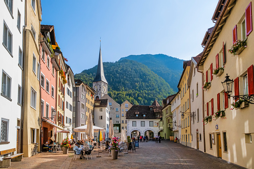 The Arcas, surrounded by rows of historic houses, is one of the beautiful squares in Chur, the capital town of the Swiss canton of Graubunden. People are sitting at the outdoor tables of the cafés.