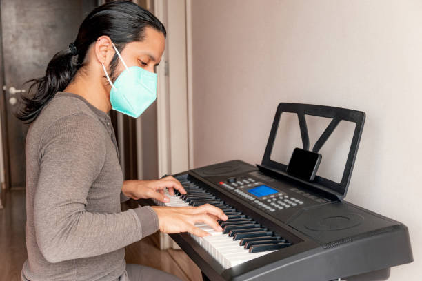 istock Young latin man playing piano at home 1316467612