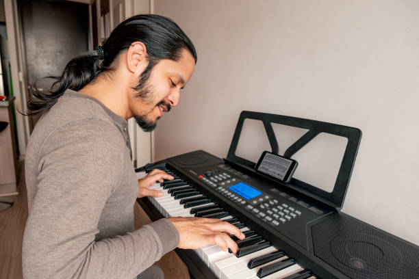 istock Young latin man playing piano at home 1316467632