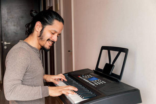 istock Young latin man smiling learning to play piano at home 1316467729
