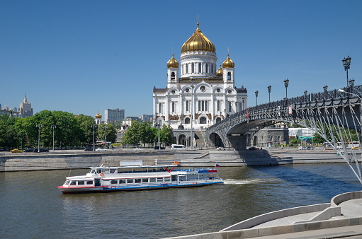 Summer view of the Cathedral of Christ the Saviour, the Patriarchal Bridge and the passing pleasure boat. Moscow, Russia