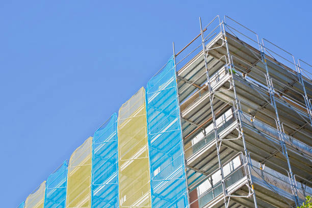 istock Metal scaffolding on a construction site built with prefabricated components to work safely on the facade of a building for the renovation of the plaster wall or realization of thermal insulation to improve the energy efficiency of the building. 1316469371