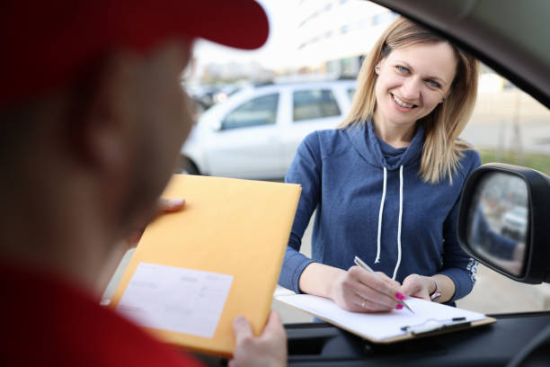 istock Female client puts signature on documents when receiving parcel from courier 1316470709