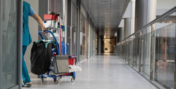 un employé tire un chariot pour nettoyer les bureaux. femme nettoyeur est engagé dans le travail. - spring cleaning photos et images de collection