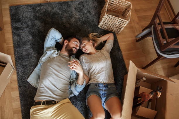 Couple moving into new home.They lying on carpet and relaxing after unpacking.