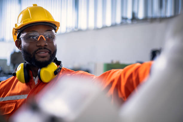 istock African engineer pointing to a robotic arm in factory. 1316477071
