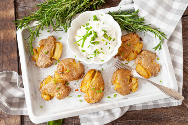 Smashed potatoes, crisp baked potatoes Smashed potatoes, crisp baked potatoes with fresh rosemary baked potato sour cream stock pictures, royalty-free photos & images