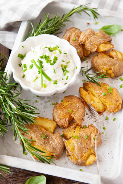 Smashed potatoes, crisp baked potatoes Smashed potatoes, crisp baked potatoes with fresh rosemary baked potato sour cream stock pictures, royalty-free photos & images