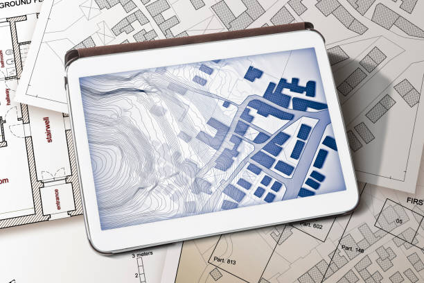 istock Imaginary cadastral map of territory with buildings and land parcel - concept image with a digital tablet - Note: the map background is totally invented and does not represent any real place 1316479863