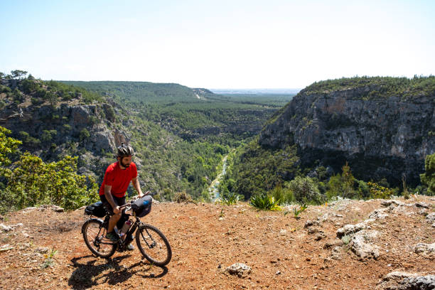 молодой езда на велосипеде со всей своей мощью в каньон пейзаж в экстремальной местности, склон - bicycle racing bicycle isolated red стоковые фото и изображения