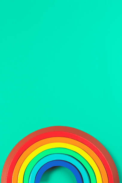 istock Kid toy wooden stacking rainbow on light green background. Top view 1316482976