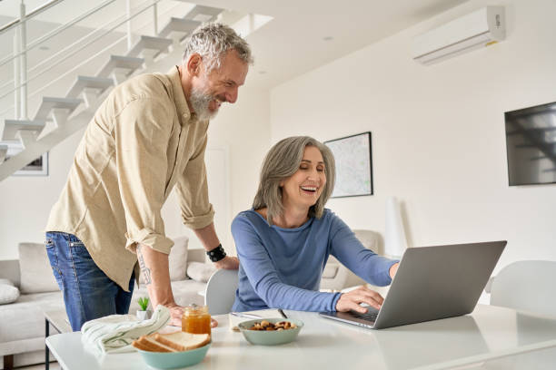 istock Happy middle aged couple having fun using laptop computer at home. 1316483025