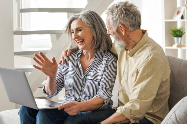 happy mature old couple waving having virtual meeting on laptop at home. - 3666 imagens e fotografias de stock