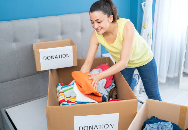 istock Woman putting clothes into boxes for donations at home. 1316483150