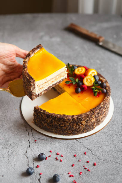 istock Cheese cake with mango fruit on a grey background. Cheese cake with passion fruit sauce on top, decorated with berries and fruits 1316486498